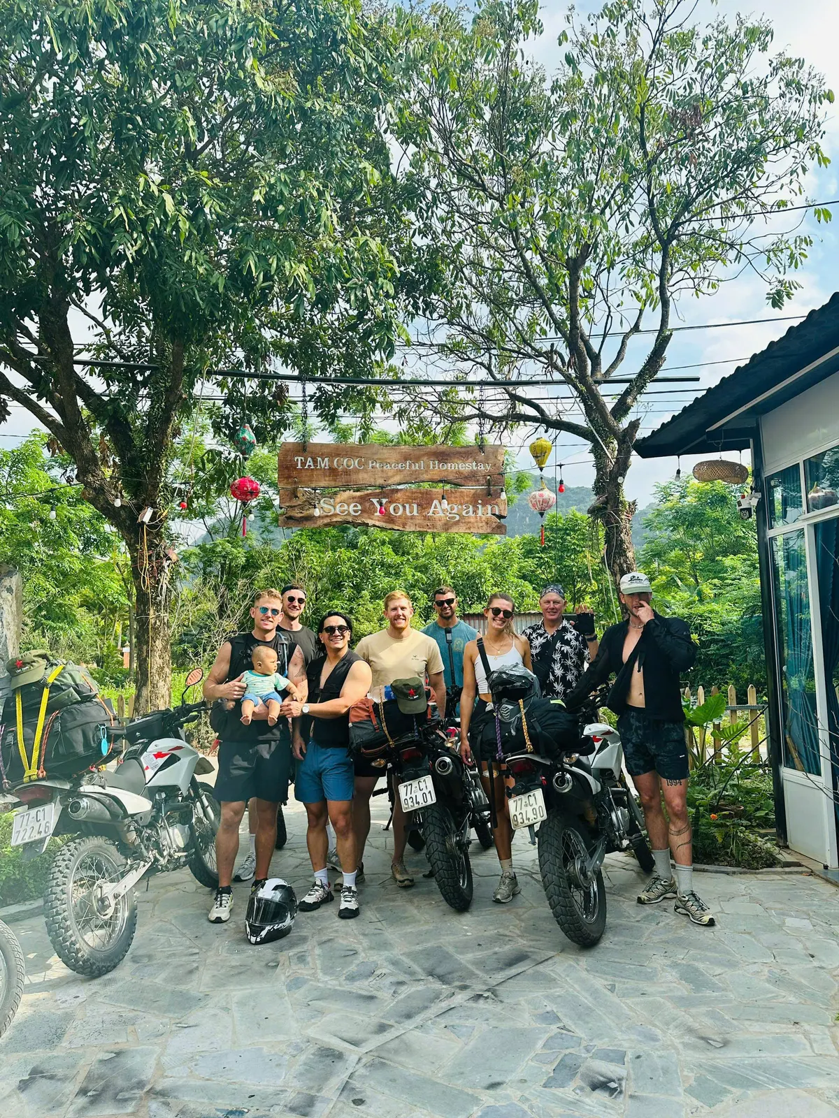 Guests with motorbikes in the leafy homestay courtyard